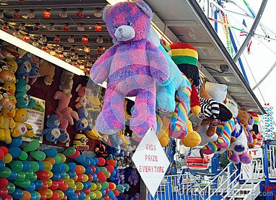 many stuffed animals are hanging from the ceiling in front of an amusement park ride area