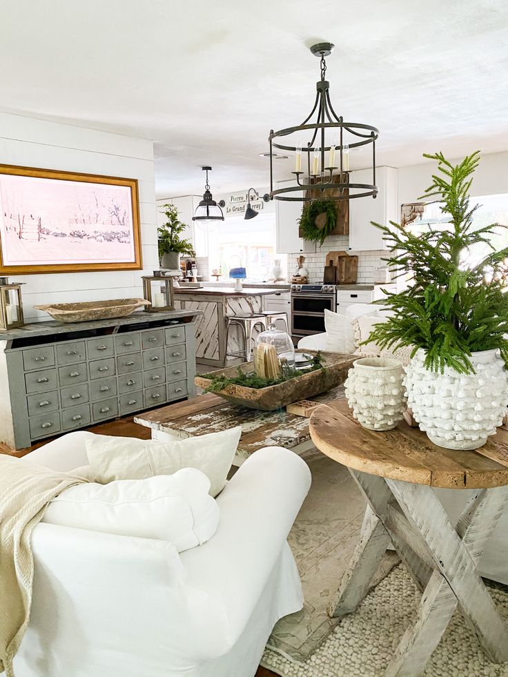 a living room filled with lots of furniture and plants on top of wooden tables next to each other