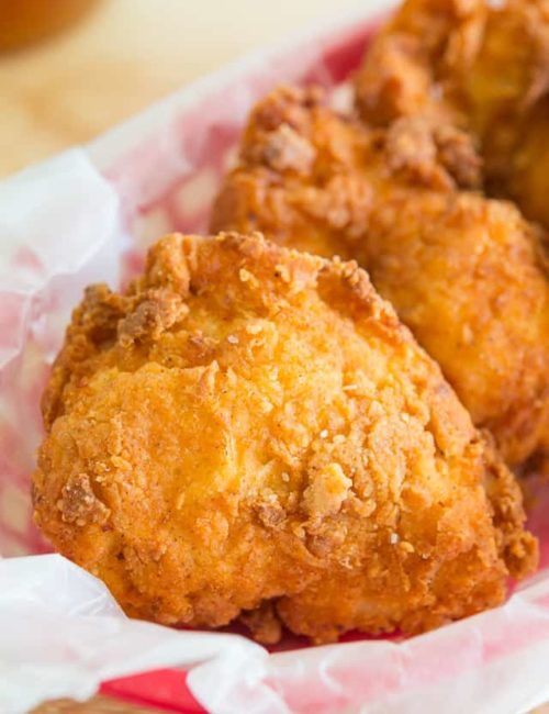 three fried food items in a basket on a table