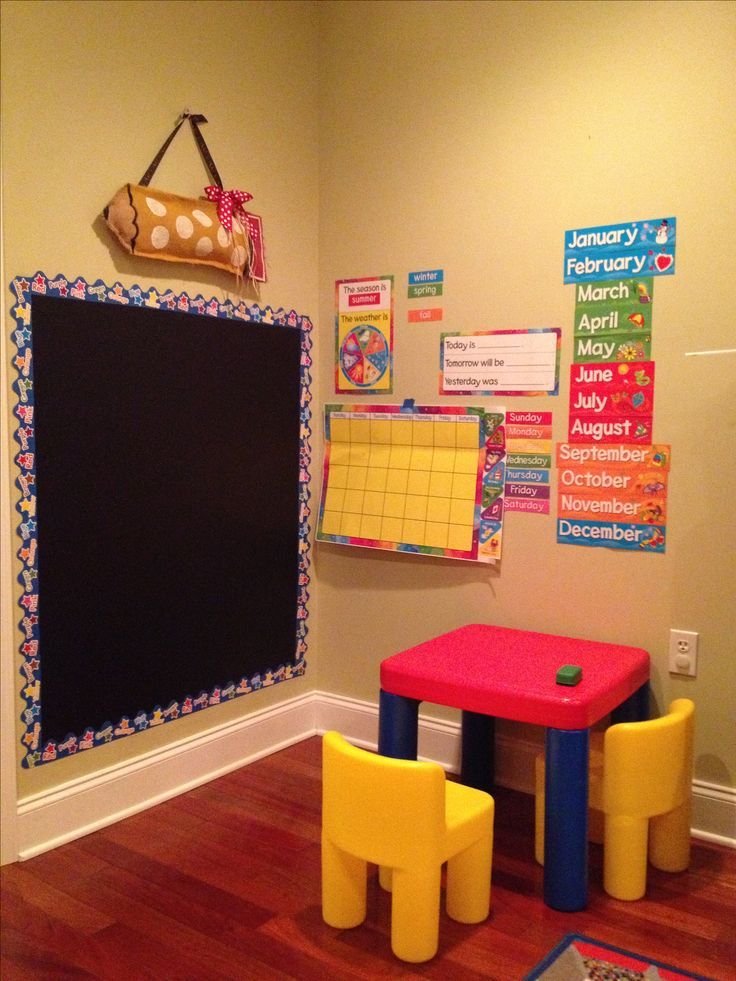 a child's playroom with colorful chairs and a chalkboard on the wall