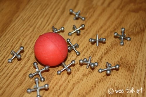 a red ball surrounded by silver crosses on a wooden table