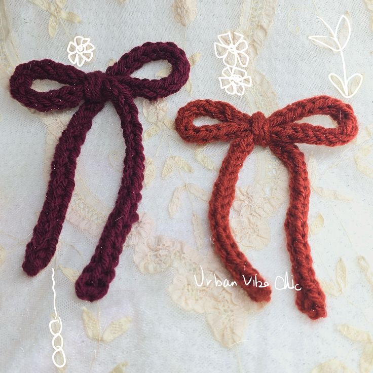 two crocheted hair ties tied together on a lace tablecloth with flowers in the background