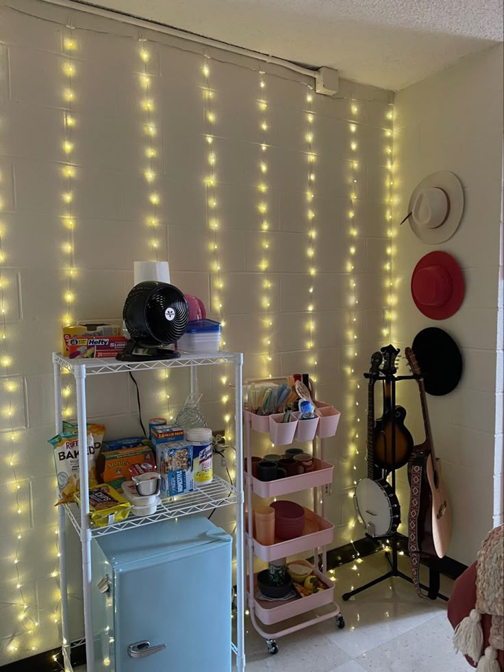 a room that has some lights on the wall and a refrigerator in front of it