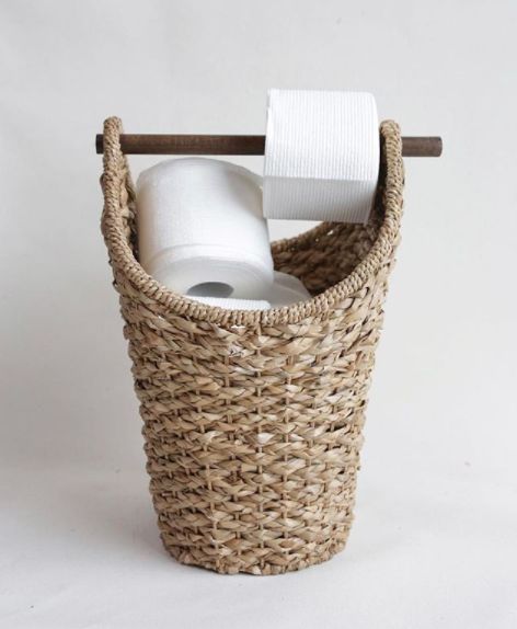 a wicker basket with two rolls of toilet paper in it