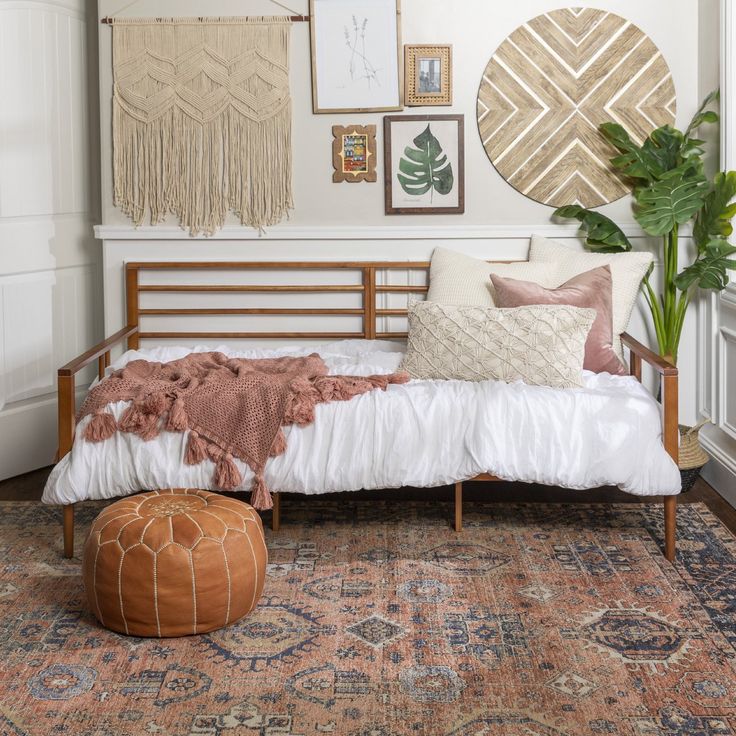 a bedroom with a bed, rugs and pictures on the wall above it is shown