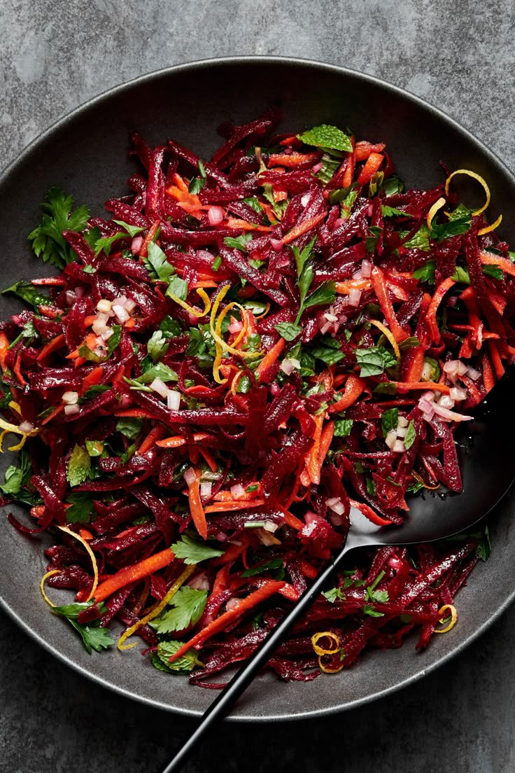 a bowl filled with beets and carrots on top of a gray countertop