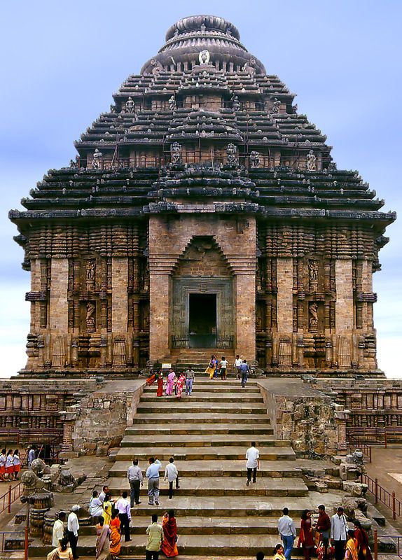 many people are walking up and down the stairs in front of an old building that is made of stone