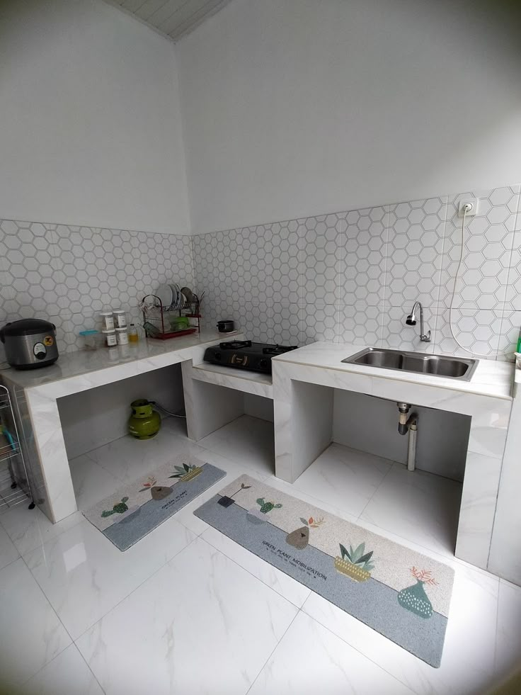 a kitchen with white walls and flooring has two sinks in the center, one on the other side