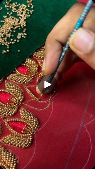 a person is working on an intricately designed piece of cloth with beading and sequins