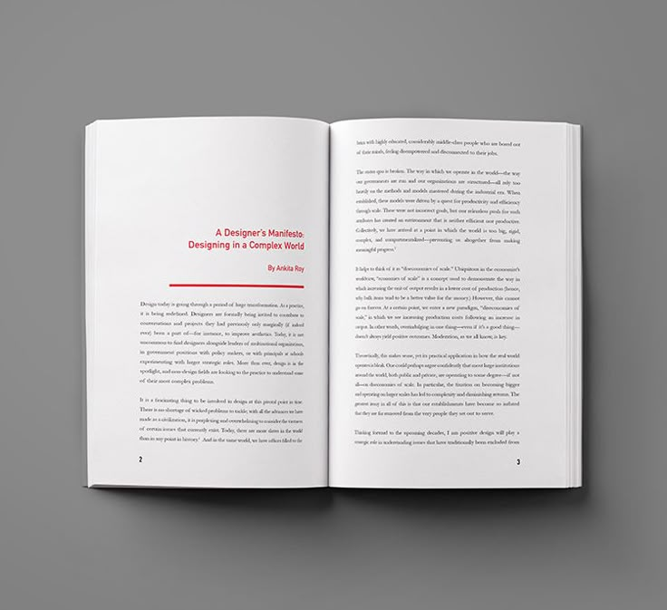 an open book with red text on the front and back cover, sitting on top of a gray surface