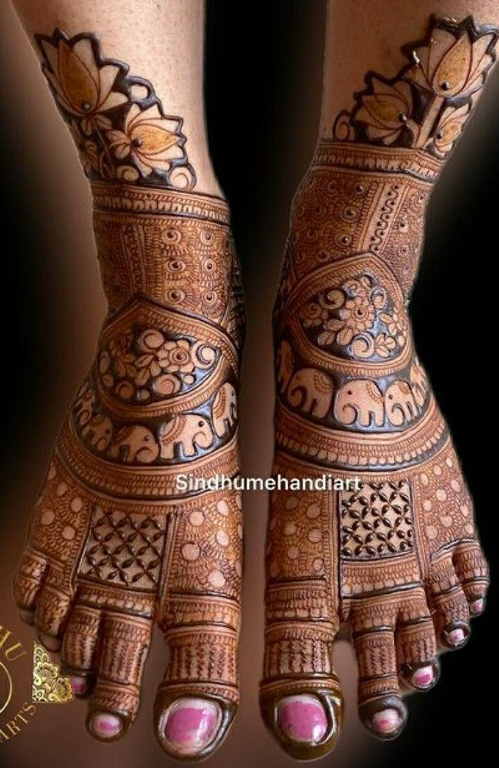 the feet and hands of a woman with henna tattoos