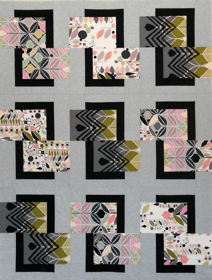 an abstract quilt with black, white and pink designs on it's sides is shown