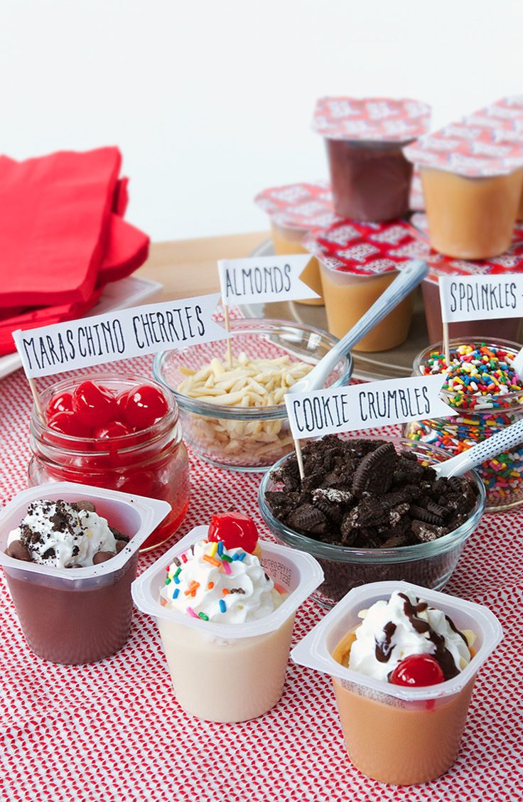 an assortment of desserts are displayed in plastic containers on a red and white checkered tablecloth