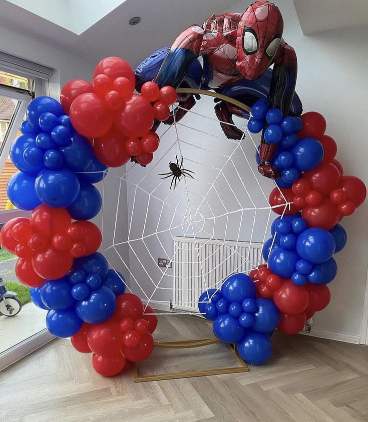 a spiderman balloon arch with red, white and blue balloons