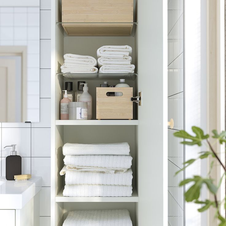 the shelves in this bathroom are filled with white towels and other bath products, along with toiletries