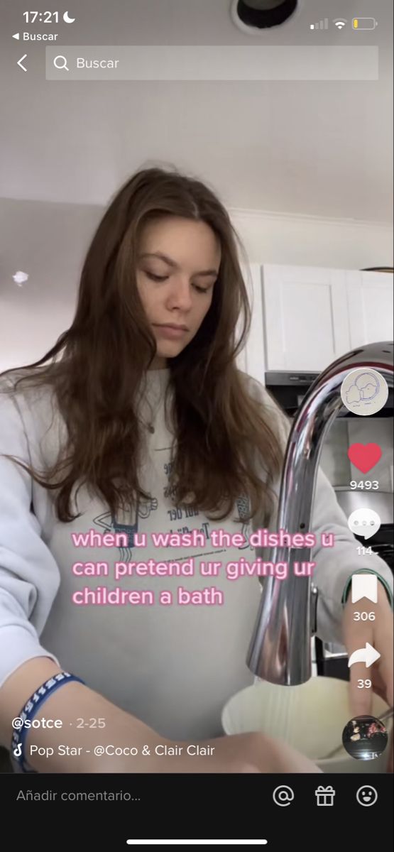 a woman is washing her hands in the kitchen sink while looking at something on her phone