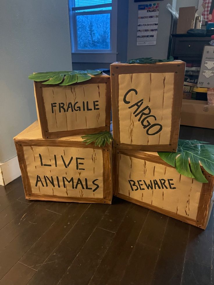 three wooden boxes with words on them sitting on the floor in front of a window