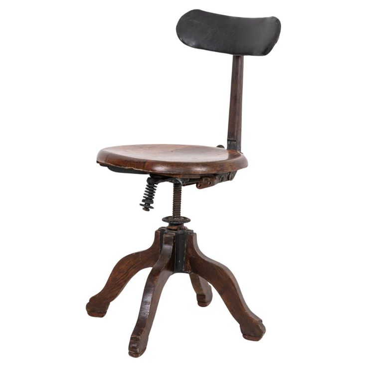 an old fashioned desk chair with a wooden seat and foot rest on the backrest