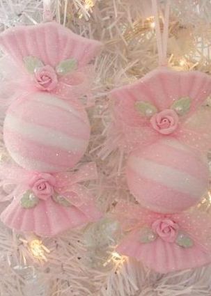 pink and white ornaments hanging from a christmas tree