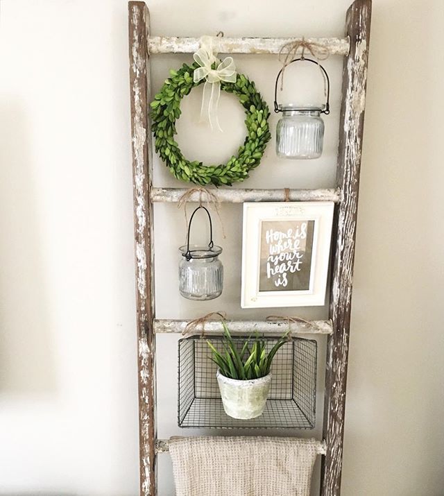 an old ladder is used as a shelf to display plants and other things on the wall