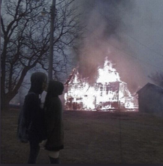 two people standing in front of a fire that has been set alighted from the ground