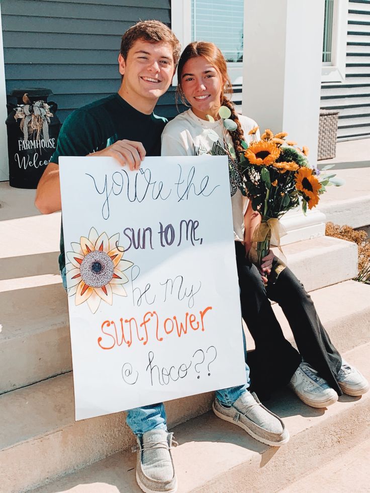 a man and woman holding a sign that says you're the sun to me