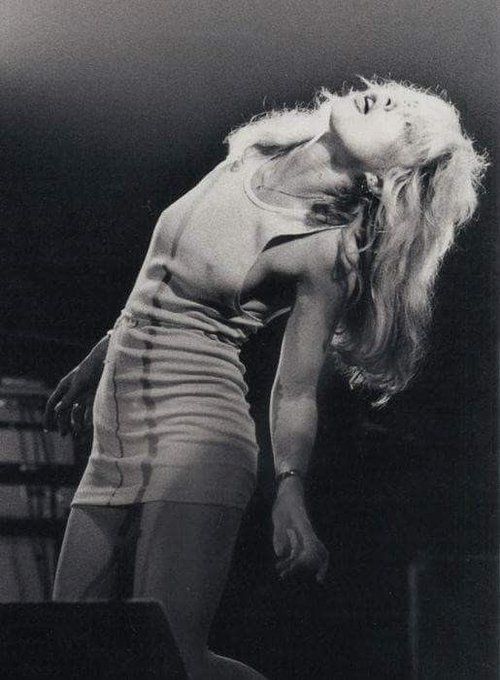 a black and white photo of a woman in tights on stage with her head down