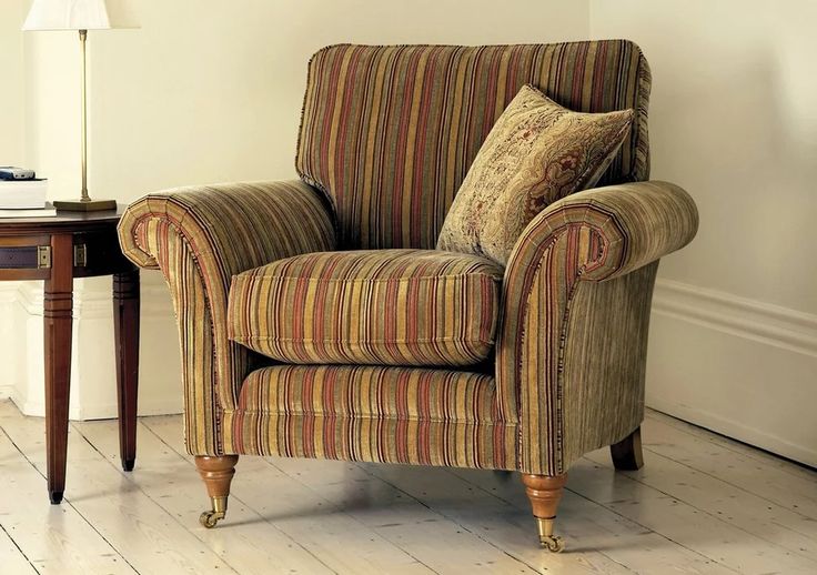 a striped chair sitting next to a table with a lamp on it