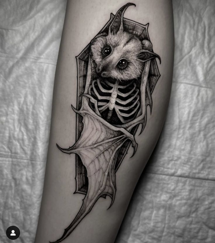 a black and white photo of a bat with a skeleton on it's leg