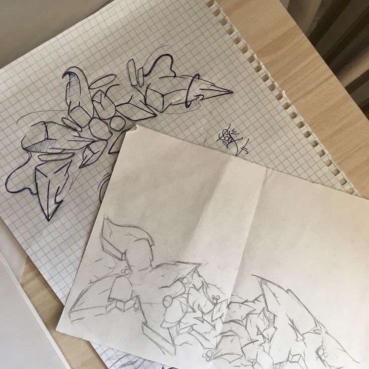 some drawings are laying on top of a piece of paper and next to each other