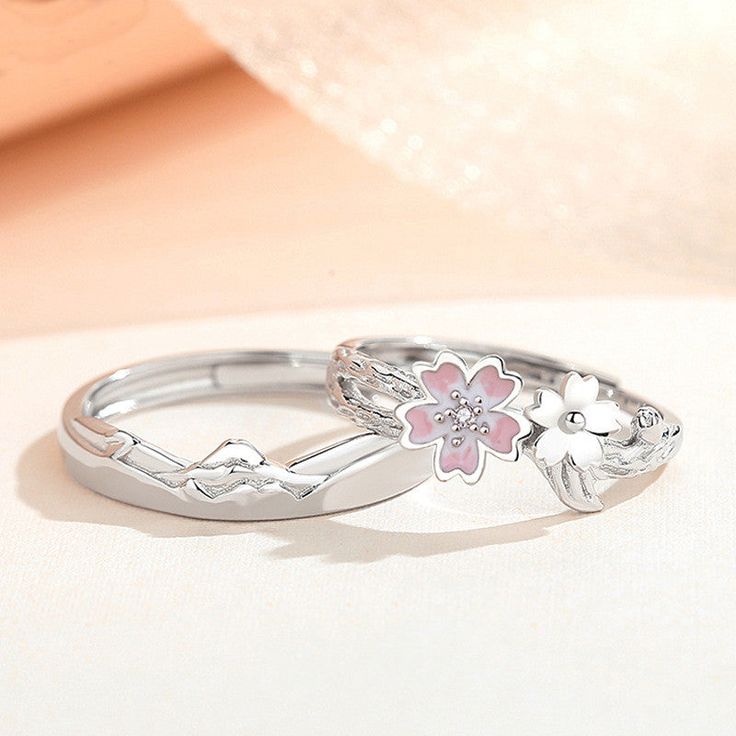 Description & Details Immerse yourself in the ethereal beauty and fleeting nature of cherry blossoms with our exquisite pieces inspired by these delicate blooms. Each design in our collection is meticulously crafted to capture the grace and elegance of cherry blossoms in full bloom. • Material: Solid 925 Sterling Silver ∙ Cubic Zirconia ∙ Enamel• Finish: Hypoallergenic ∙ Gold Plating• Dimensions: US size adjustable• All our work is custom made by hand with love Matching Promise Rings, Mountain Couple, Flower Mountain, Cherry Blossom Flower, Cherry Blossom Flowers, Couple Ring, Cubic Zirconia Jewelry, Couple Jewelry, Wedding Rings Unique