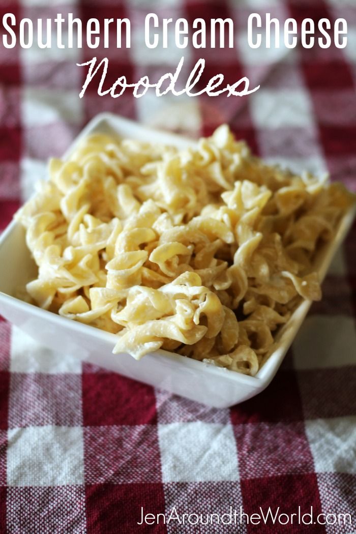 homemade southern cream cheese noodles in a white bowl on a red and white checkered tablecloth