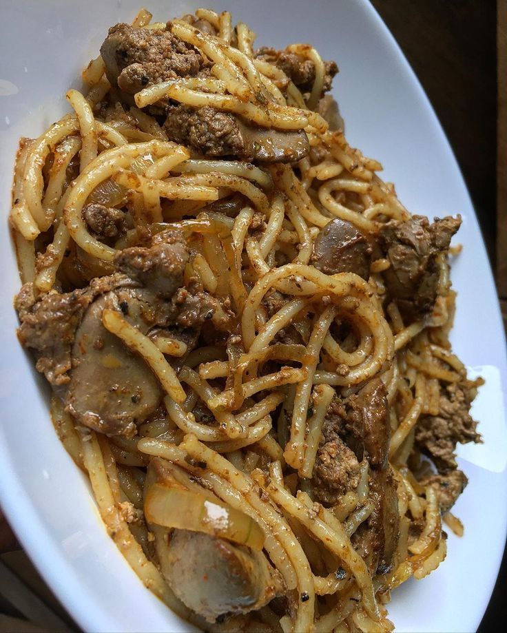 a white plate topped with pasta and meat