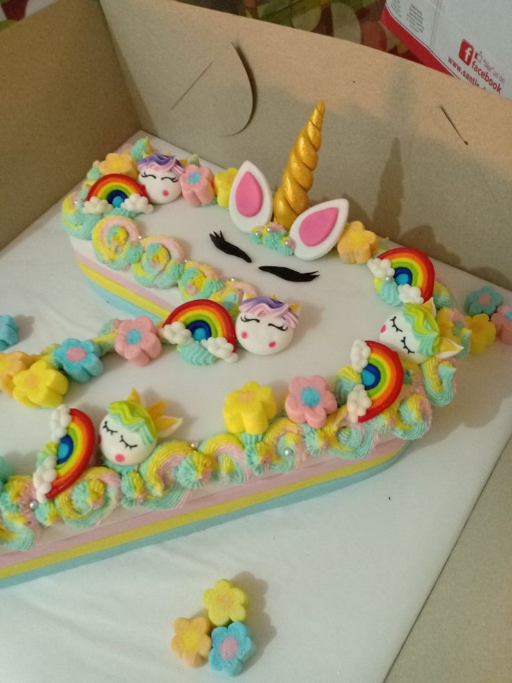 a cake in the shape of a unicorn with rainbows and stars on it's sides