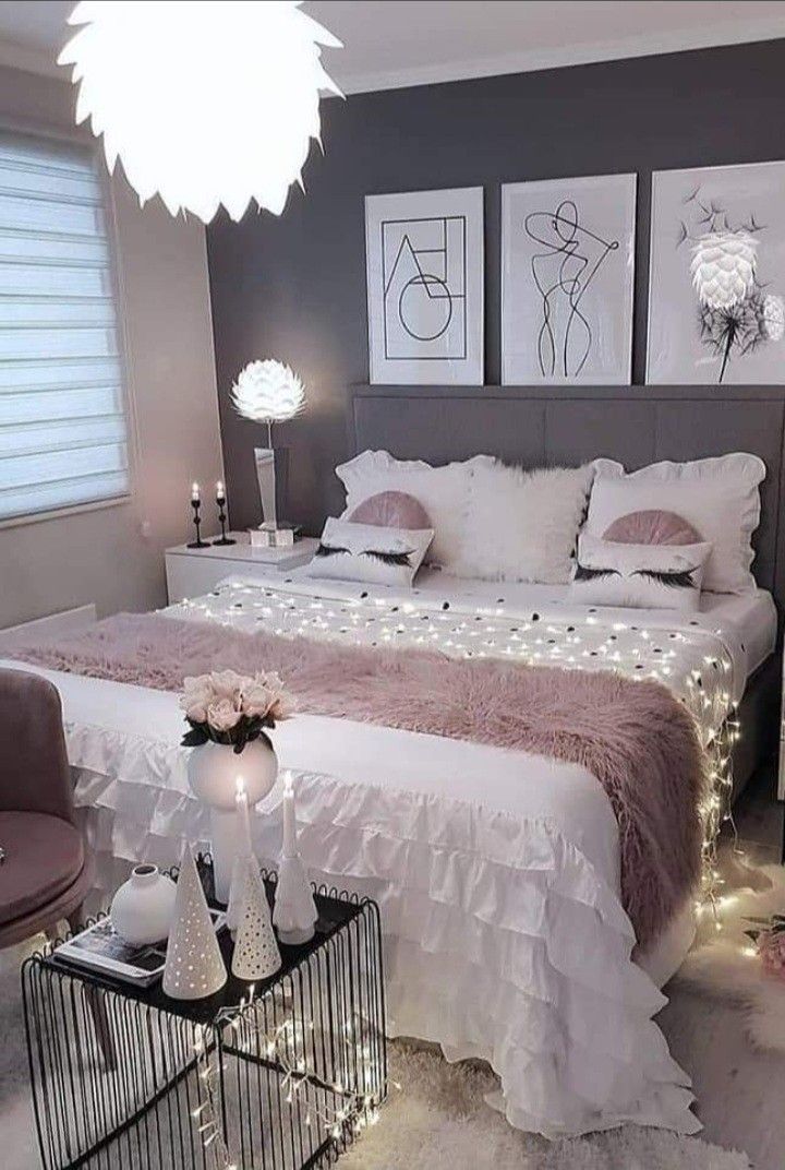 a bedroom with white and pink decor on the walls, lights in the ceiling and pictures above the bed