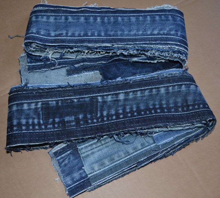 three pieces of blue jean sitting on top of a cardboard box