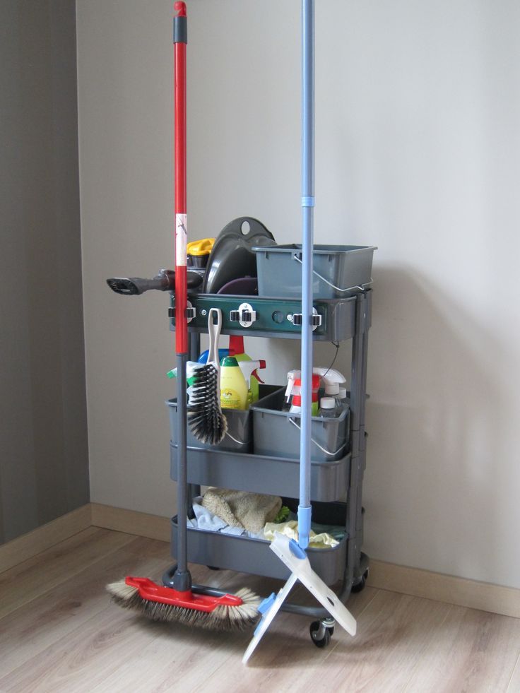 a mop, buckets and cleaning supplies on a cart in the corner of a room