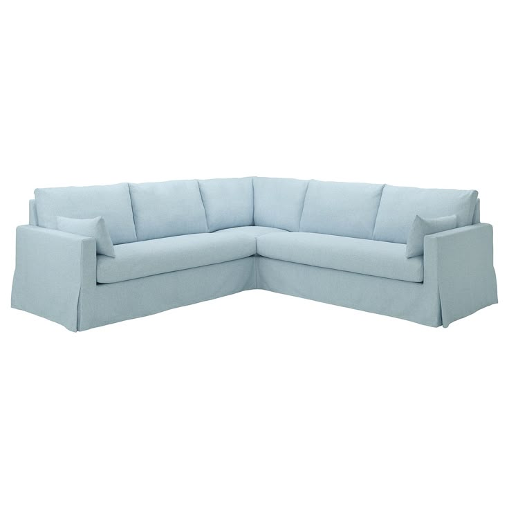 a blue sectional couch with pillows on the top and bottom corner, facing away from the camera