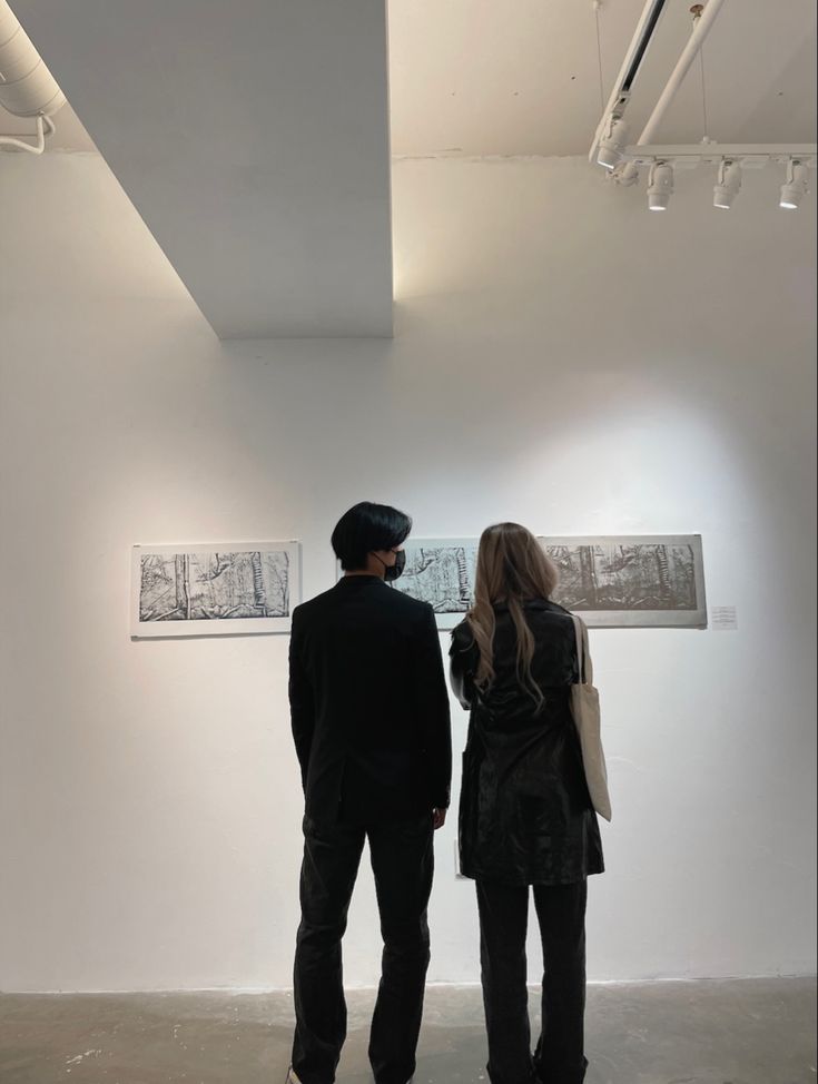 two people looking at artwork in an art gallery