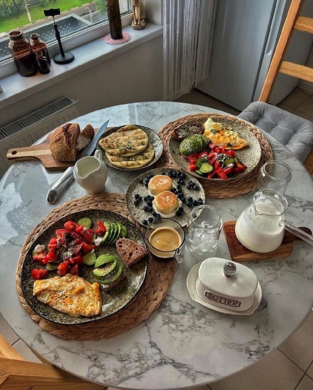 a table topped with plates of food next to a window