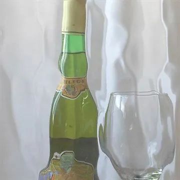 a bottle and glass sitting on a table