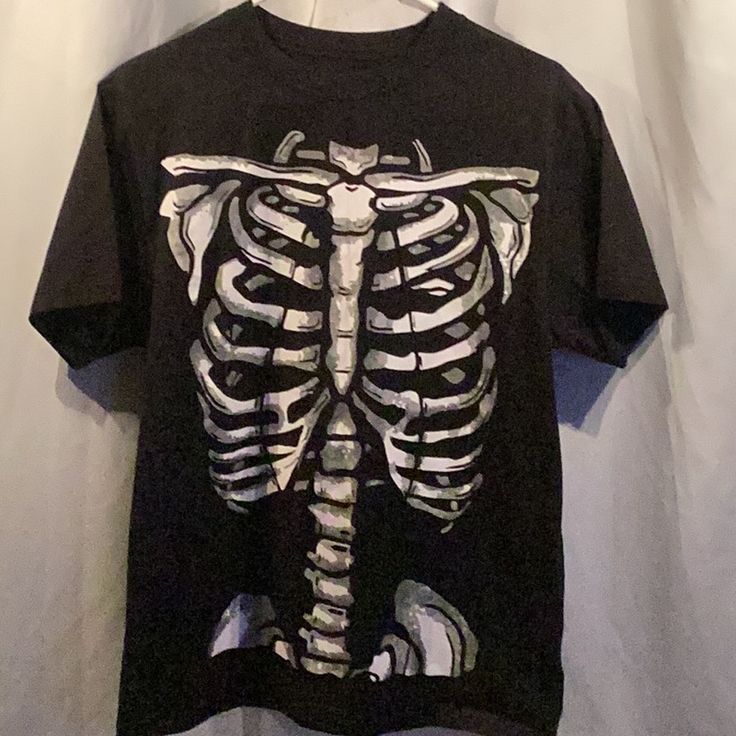 Brand New Black T-Shirt Just In Time For Halloween. Look Stylish Straight From The Graveyard When You Dress Up In This Skeleton Rib Cage T-Shirt. This Black T-Shirt Features A White Skeletal Graphic Printed On The Entire Front Of Shirt. Blank On The Backside. The Perfect Shirt For A Spooky Halloween Night Of Fright! This Soft Comfy Standard Fit Shirt Is Made From 100% Polyester. *Actual Item Purchases Shown In Photo. Color May Vary Due To Camera Flash And Color Variations Of Computer / Phone Scr Skeleton Rib Cage, Halloween Graphic, T Shirt Costumes, Camera Flash, Skeletal, Halloween Night, Rib Cage, Graveyard, Spooky Halloween