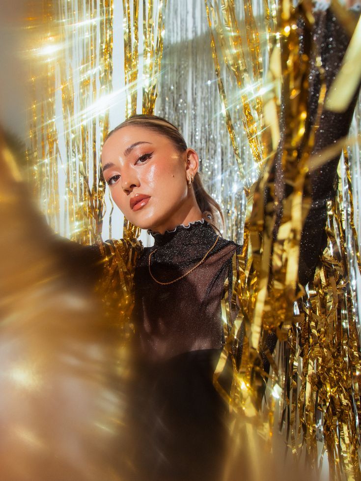 pretty girl wearing a Black sheer turtle neck and gold chain. surrounded by gold shiny curtains. Nye Photoshoot Studio, New Years Eve Photoshoot Ideas Home, New Years Party Photoshoot, Glitter Backdrop Photoshoot, Tinsel Backdrop Photoshoot, New Years Self Portrait, Nye Photoshoot Ideas At Home, Glitz And Glam Photoshoot, Tinsel Photoshoot