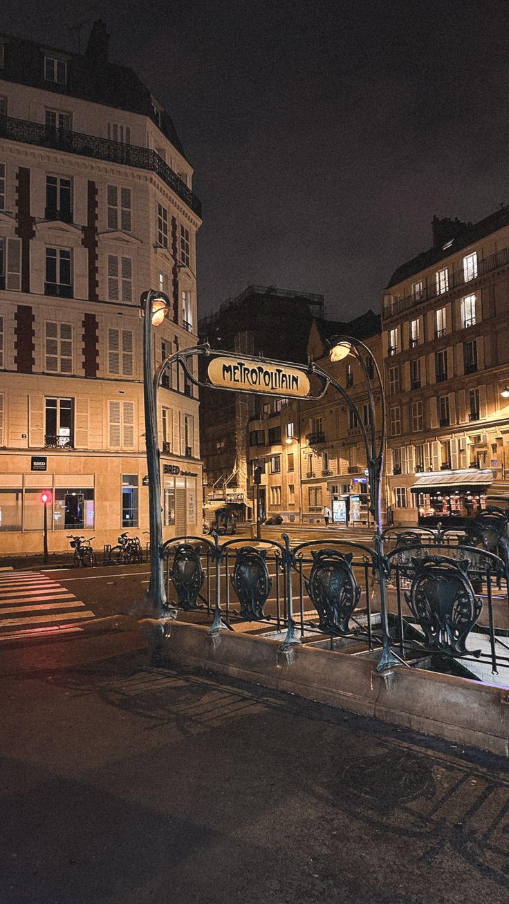 an empty city street at night with no one on the sidewalk or in front of it