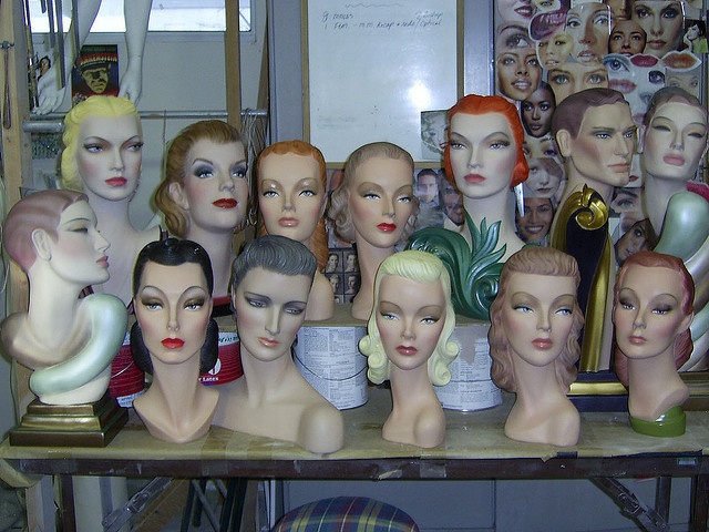 there are many mannequin heads on the table