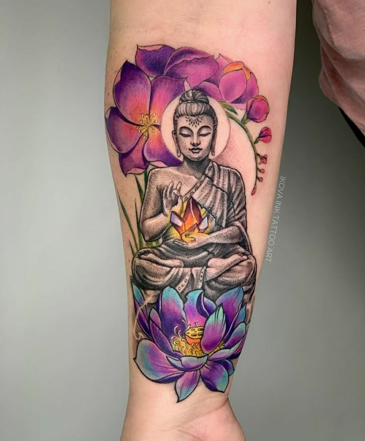 a person with a tattoo on their arm holding a flower and buddha statue in front of them