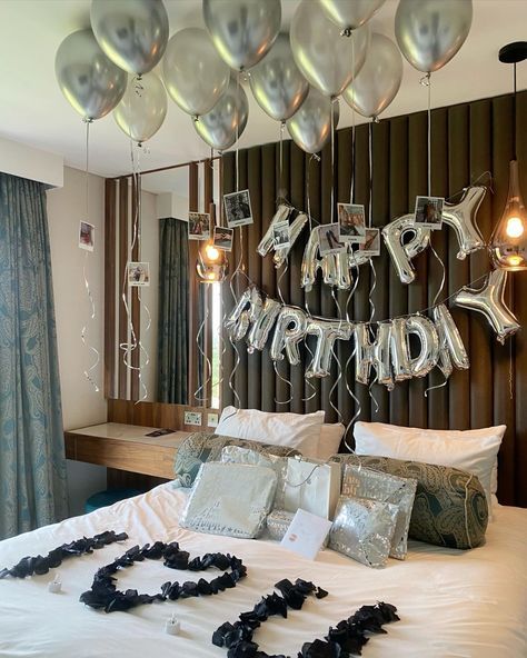 a bedroom decorated with balloons and streamers in the shape of letters that spell happy birthday