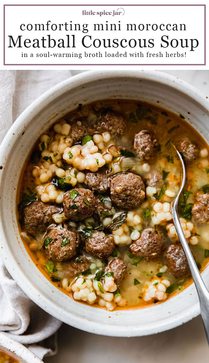 a white bowl filled with meatball couscous soup and garnished with fresh herbs