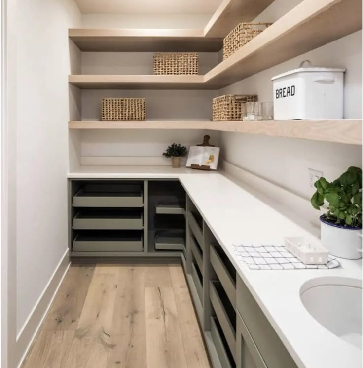 an empty walk in closet with lots of shelves and bins on the wall next to it