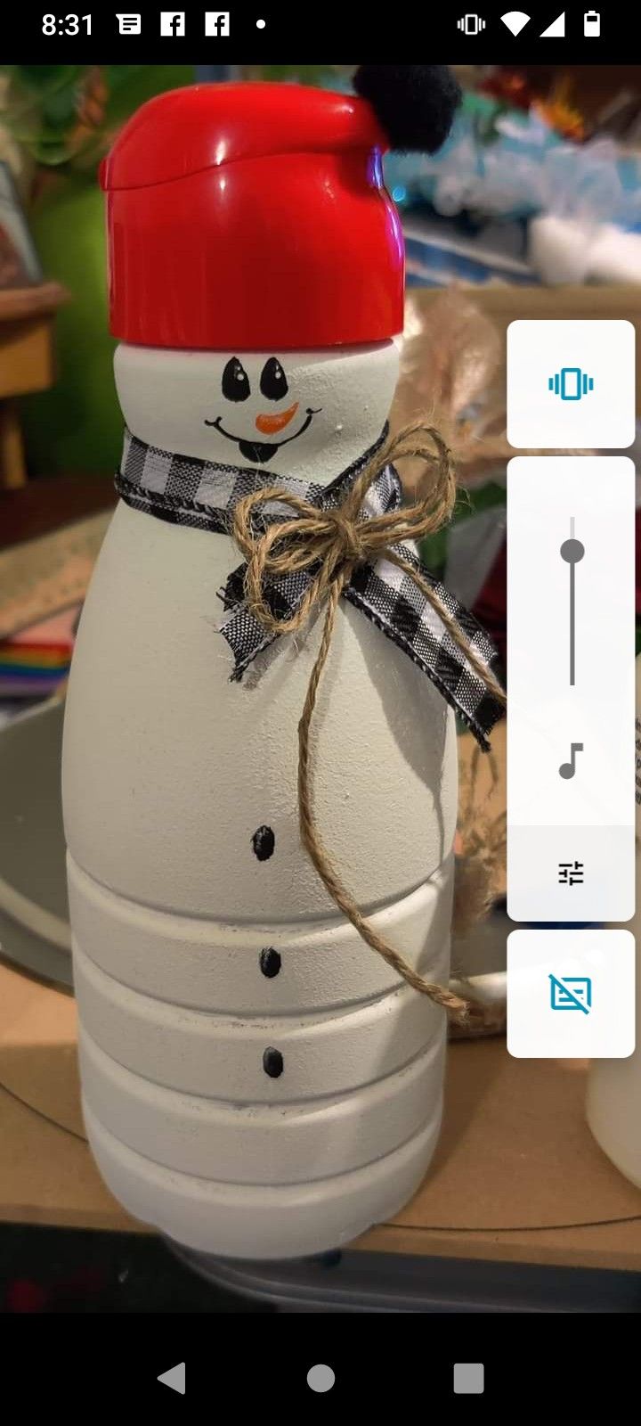 a snowman bottle with a red cap on it's head is sitting on a table